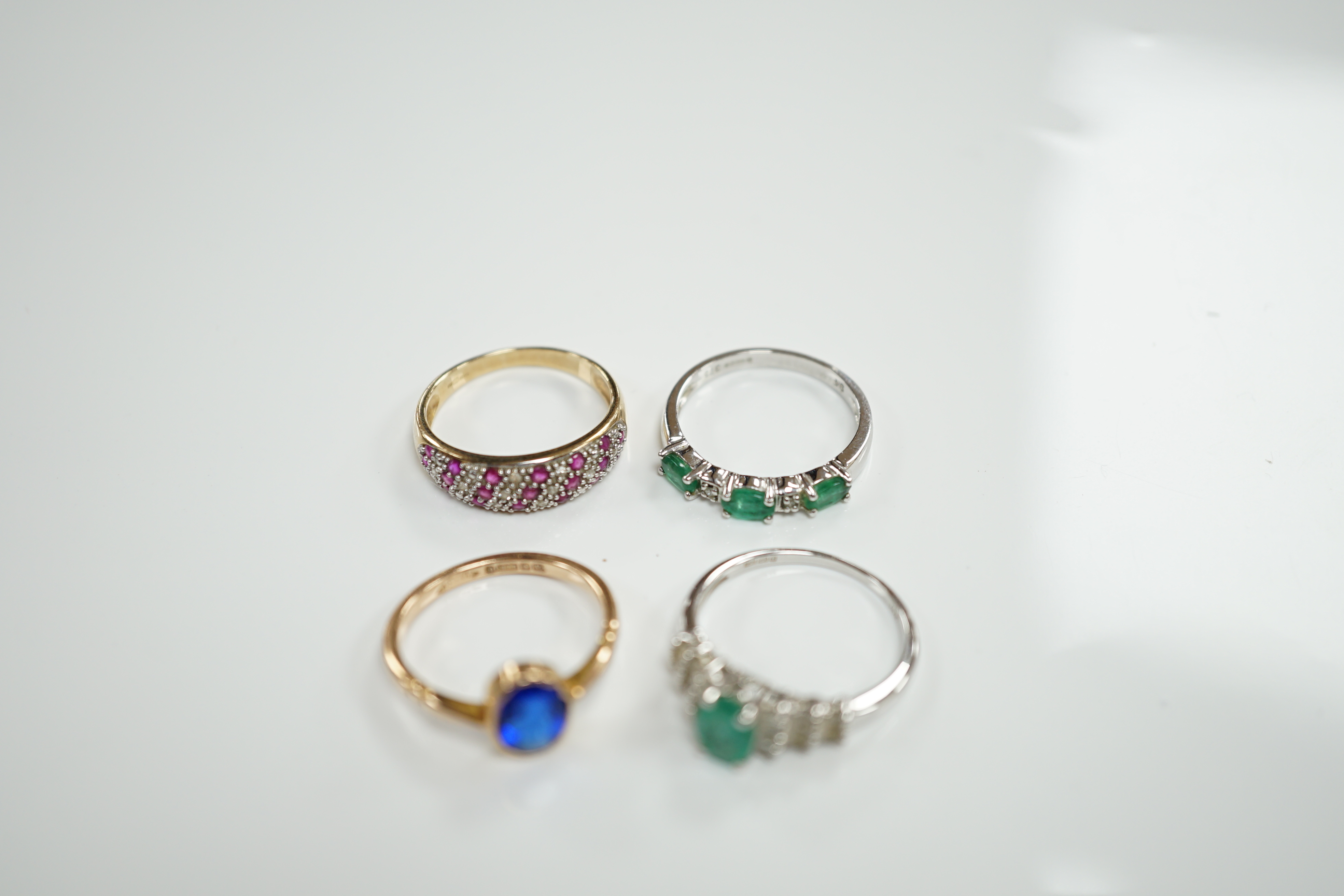 Three assorted modern 9ct gold and gem set rings including emerald and diamond chip set half hoop, size N, gross weight 6.8 grams and a modern14ct white gold and single stone emerald set dress ring, with baguette cut dia